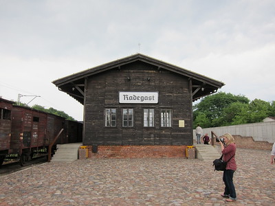 color photo of radegast station in the center with a train pictured in the left hand side