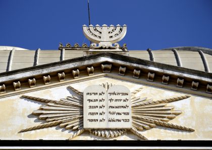 stone plaque of the 10 commandments with a stone menorah placed on the top of the synagogue