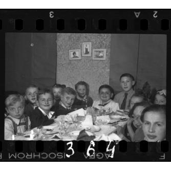 black and white photo of about a dozen smiling children at a table